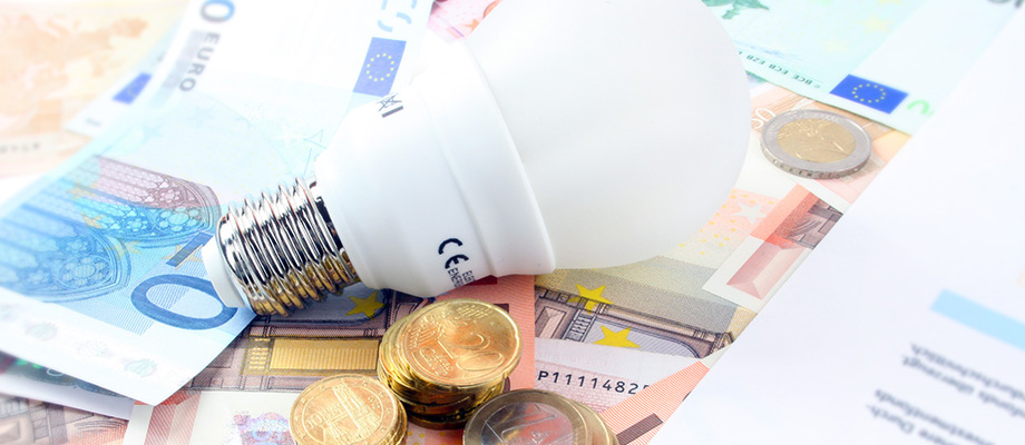 Energiesparlampe mit Euro-Münzen, verdeutlicht die Einsparungen durch nachhaltige Beleuchtungslösungen.